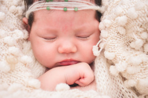 Newborn Girl sleeping ina blanket with a headband on Greer, SC